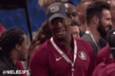 Man In Maroon Shirt Talking To Woman In Crowd GIF