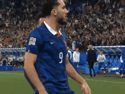 Man In Maroon Shirt Walking On Soccer Field GIF