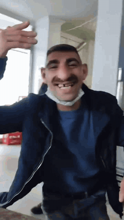 Man In Mask And Blue Shirt Making Funny Face GIF