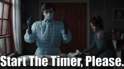 Man In Mask And Gloves Next To Woman Saying Start The Timer Please GIF