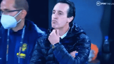 Man In Mask And Jacket Sitting With Hand On Chin GIF