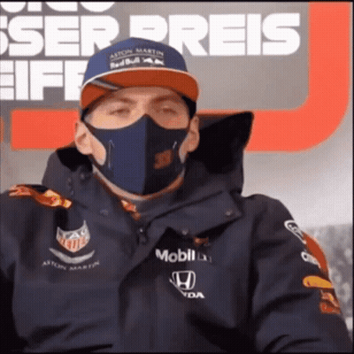 Man In Mask And Red Bull Hat Sitting In Front Of Preis Sign GIF