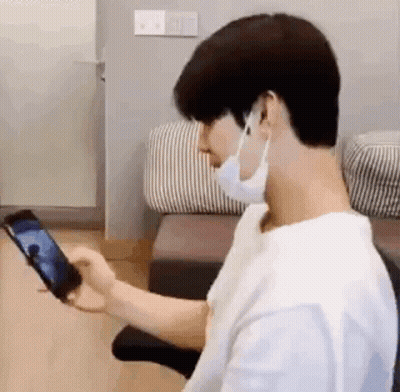 Man In Mask Holding Cell Phone GIF