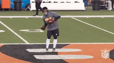 Man In Mask Holding Football On Field GIF