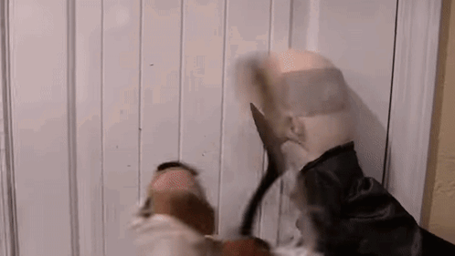 Man In Mask Holding Scissors In Front Of Door GIF