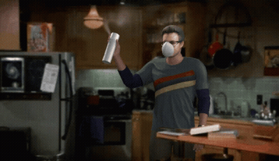 Man In Mask Holding Spray Bottle In Kitchen GIF