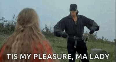 Man In Mask Holding Sword Next To Woman In Field GIF