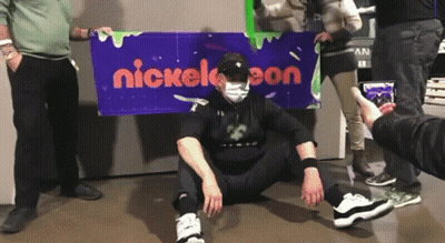 Man In Mask In Front Of Nickelodeon Sign GIF