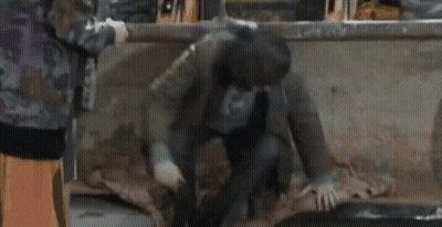 Man In Mask Kneeling With Woman Behind GIF