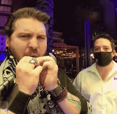 Man In Mask Next To Man In Bu Shirt GIF