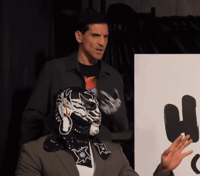 Man In Mask Next To Man In Suit GIF