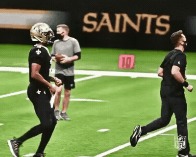 Man In Mask Running On Football Field While Another Throws Ball GIF