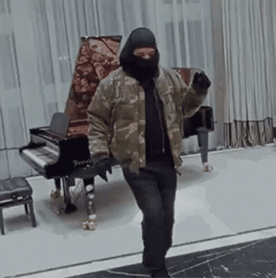 Man In Mask Standing At Piano GIF