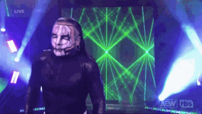 Man In Mask Standing In Front Of AEW Screen GIF