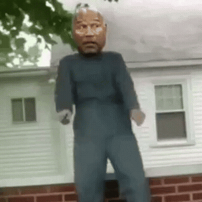 Man In Mask Standing In Front Of Brick Building GIF