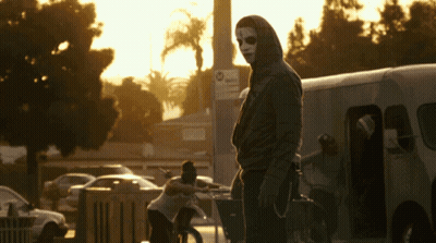 Man In Mask Standing In Front Of No Parking Sign GIF