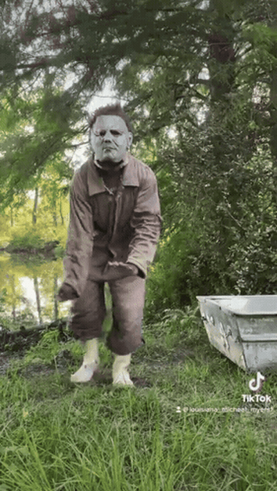 Man In Mask Standing Near Lake GIF