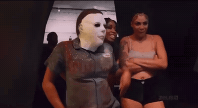 Man In Mask Standing Next To Two Women In Underwear GIF
