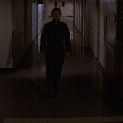 Man In Mask Walking Down Hallway With Knife GIF