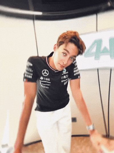Man In Mercedes Shirt Beside Sign 44 GIF