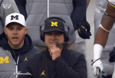 Man In Michigan Hat And Headphones Talking GIF