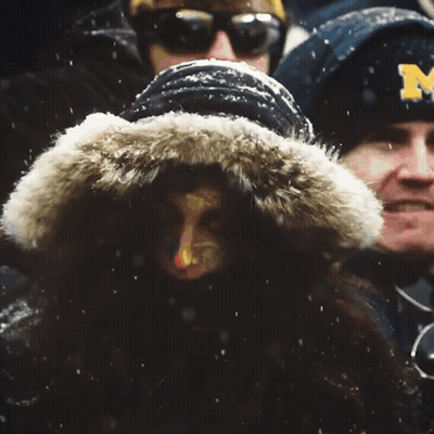 Man In Michigan Jacket Stands In Crowd GIF