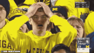 Man In Michigan Shirt Holding Head GIF
