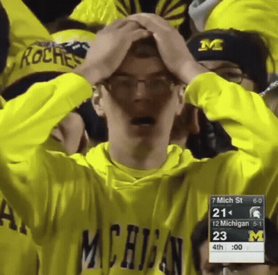 Man In Michigan Sweatshirt Holding Head GIF