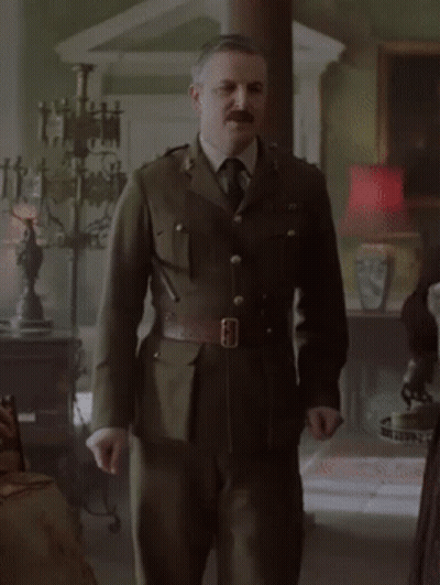 Man In Military Uniform And Tie Standing In Living Room GIF