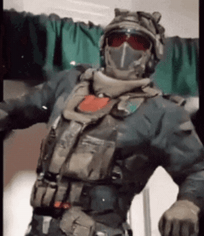 Man In Military Uniform Arms Outstretched In Front Of Green Curtain GIF