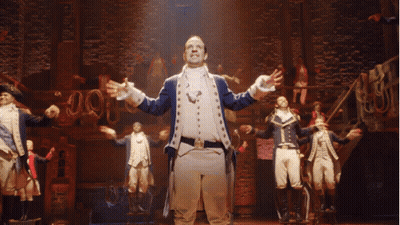 Man In Military Uniform Arms Outstretched On Stage GIF