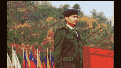 Man In Military Uniform At Podium With Flags GIF