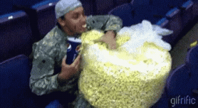 Man In Military Uniform Eating Large Bag Of Popcorn GIF