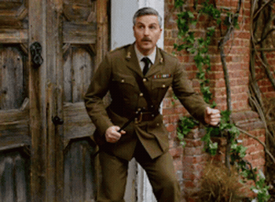 Man In Military Uniform In Front Of Brick Wall GIF