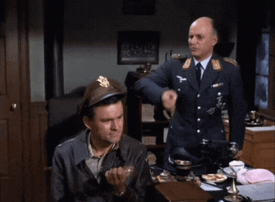 Man In Military Uniform Sitting At Desk While Another Man Laughs Behind Him GIF