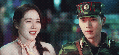 Man In Military Uniform Smiling Next To Woman In Pink GIF