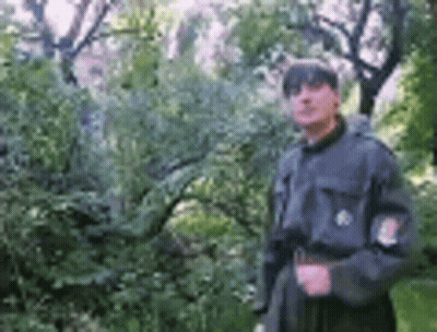 Man In Military Uniform Standing By Tree GIF