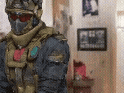 Man In Military Uniform Standing In Room With Picture GIF