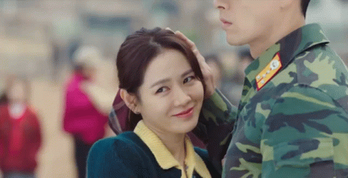 Man In Military Uniform Touching Woman's Head GIF