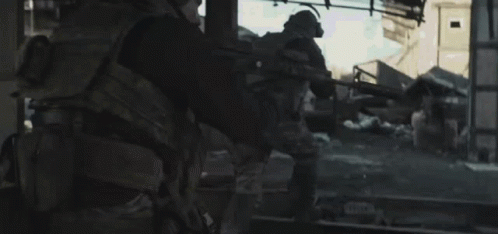 Man In Military Uniform Walking Down Street GIF