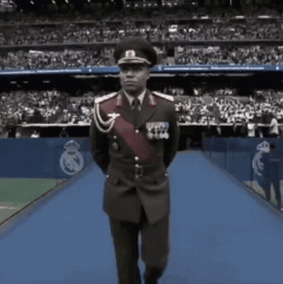 Man In Military Uniform Walking On Blue Carpet GIF