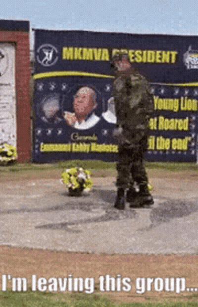 Man In Military Uniform With Flowers By MKMVA President Sign GIF