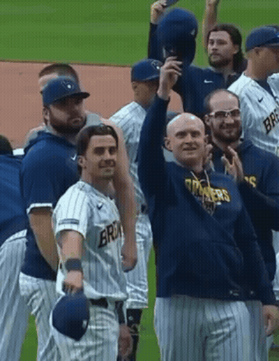 Man in Milwaukee Jersey Holding Baseball and Smiling