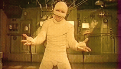 Man In Mummy Costume In Front Of Wall Number 99 GIF