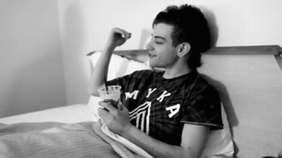 Man In Myka Shirt Laying On Bed GIF