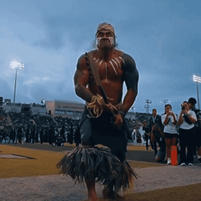 Man In Native American Costume Standing On Field GIF
