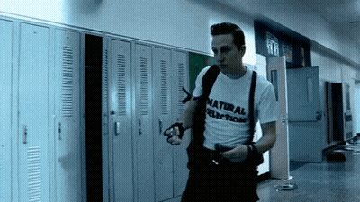 Man In Natural Selection Shirt Walking Down Hallway GIF