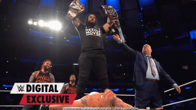Man In Needle Mover Shirt Holding Championship Belts GIF