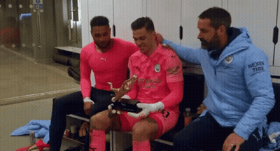 Man In Nexen Tire Jacket Sitting With Two Men GIF