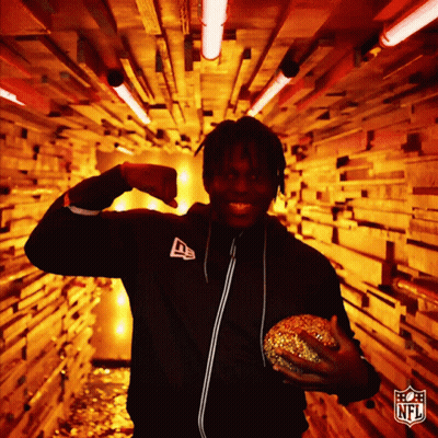 Man In NFL Jacket Holding Hamburger In Tunnel GIF